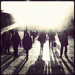 People walking in city during sunset