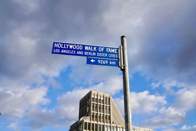 Low angle view of road sign against sky