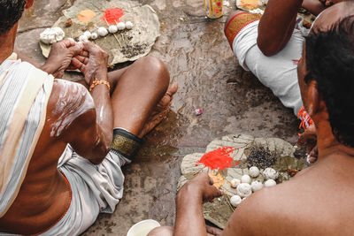 Rear view of people performing rituals outdoors