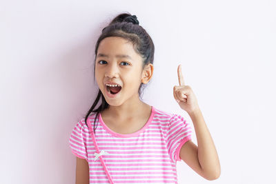 Portrait of girl standing against white background