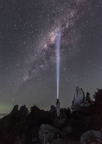 A women standing under a sunny milkyway during a clear night sky