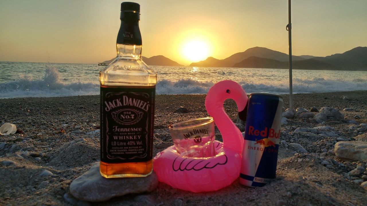 VIEW OF DRINK IN CONTAINER ON BEACH