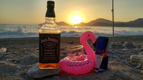 View of drink on beach during sunset