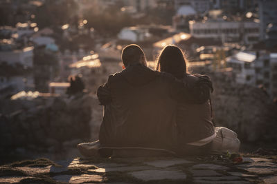 Rear view of couple sitting in city