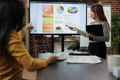 Side view of woman using digital tablet at office