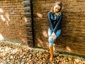 Woman standing in front of brick wall