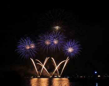 Low angle view of firework display at night