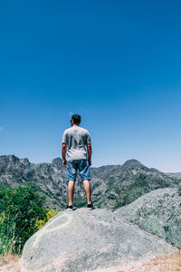 Rear view of man standing on rock