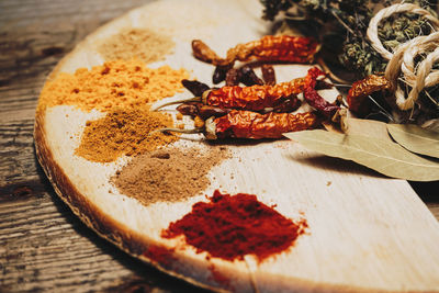 Spices and red chili peppers on table