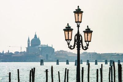 Street light by sea against clear sky