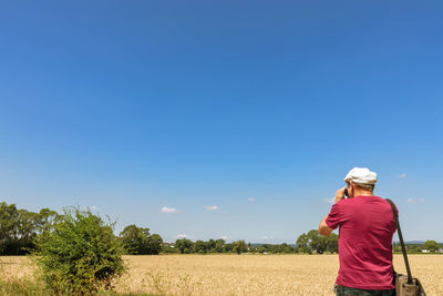 Rear view of man on field against sky