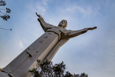 Low angle view of jesus christ against sky