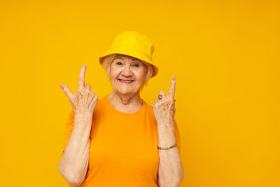 Portrait of woman against yellow background