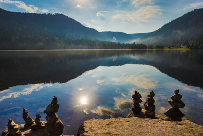 Scenic view of lake by mountains against sky