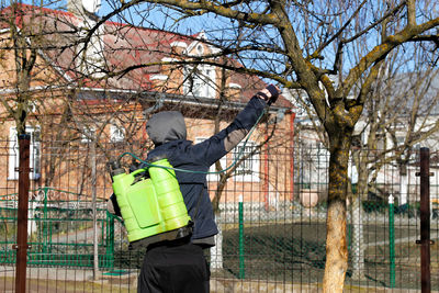 Organic ecological agriculture. defocus farmer man spraying tree with manual pesticide sprayer