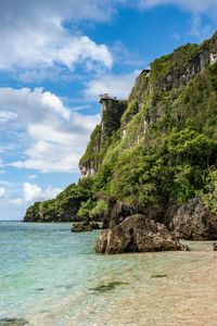 Scenic view of sea by cliff against sky