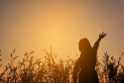 Silhouette woman against sky during sunset