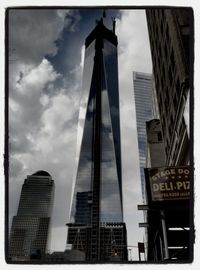 Low angle view of modern building against cloudy sky