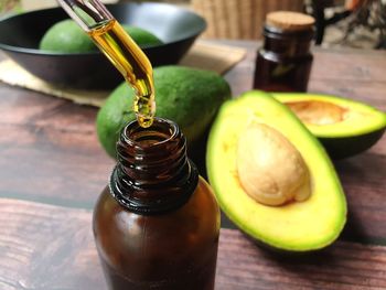 Avocados and avocado oil on wooden table