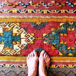 Low section of woman standing on carpet at home