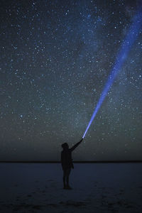 Full length of man standing against star field at night