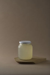 Jar of asparagus stock on a wooden cutting board with brown background