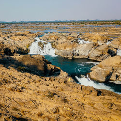 Rock formations in sea against clear sky