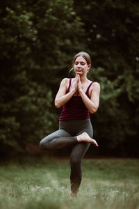 Full length of young woman doing yoga in the park