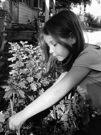 Side view of girl planting at yard