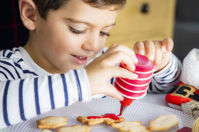 Cute boy preparing gingerbread cookies at home