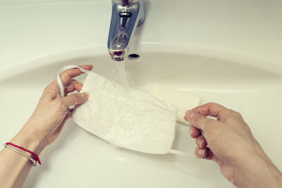 Midsection of person holding hands in bathroom