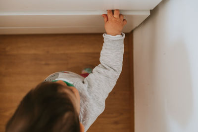 High angle view of baby girl standing by drawer at home