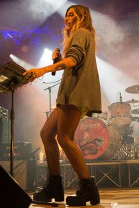 Midsection of woman standing at music concert