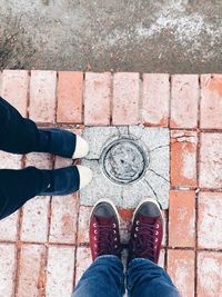 Low section of friends standing on footpath