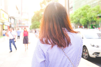 Rear view of woman standing on city street