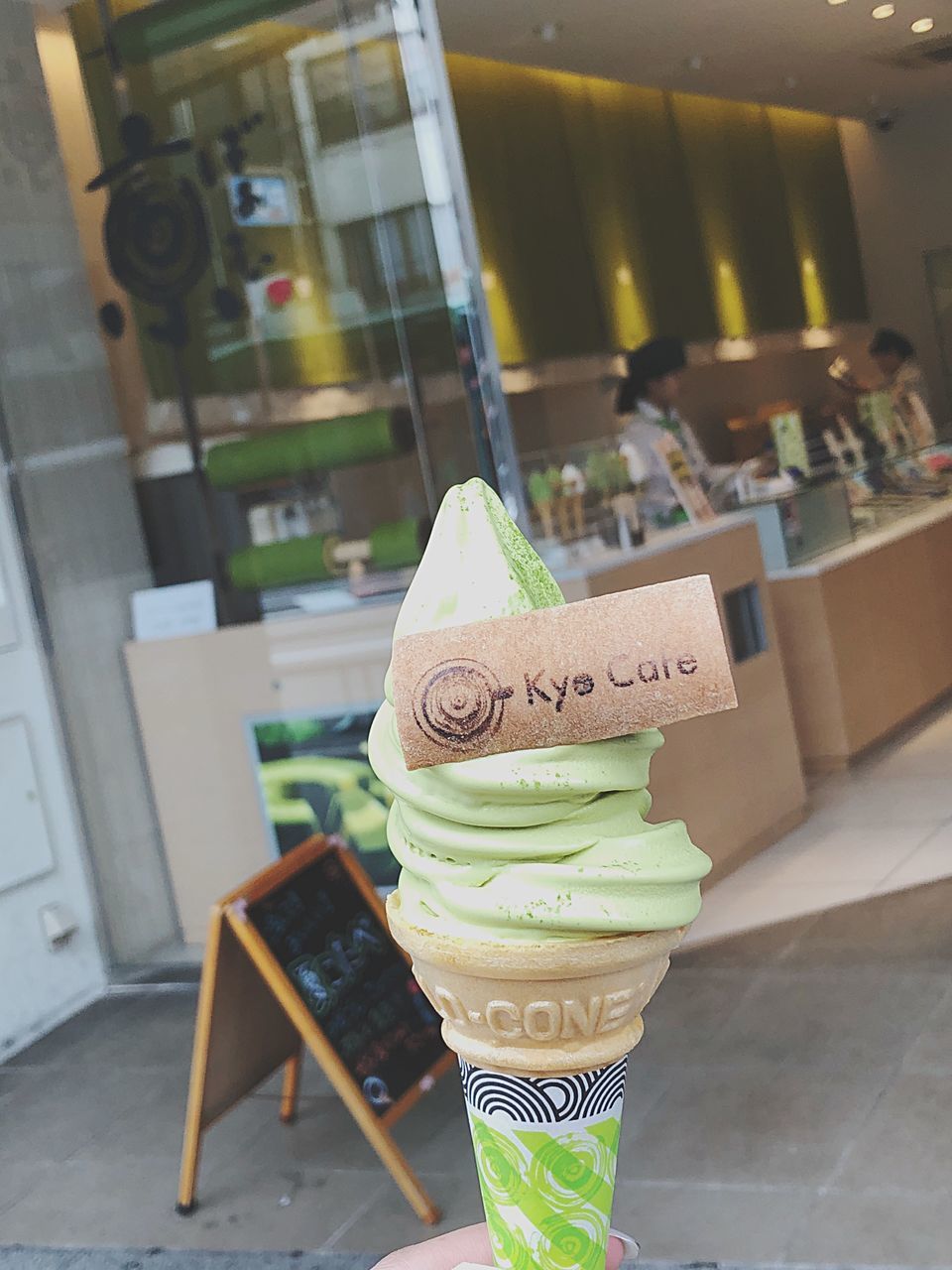 CLOSE-UP OF ICE CREAM CONE ON TABLE AGAINST WALL