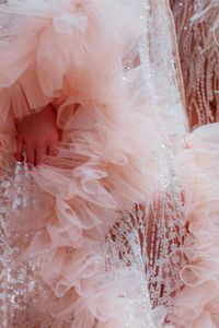 Fashion details of fluffy pastel pink haute couture boudoir dress. vertical fashion shot