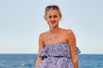 Portrait of young woman against clear sky