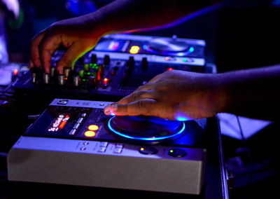 Cropped hands of dj using sound recording equipment