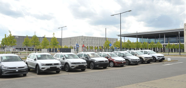 Cars on street in city against sky