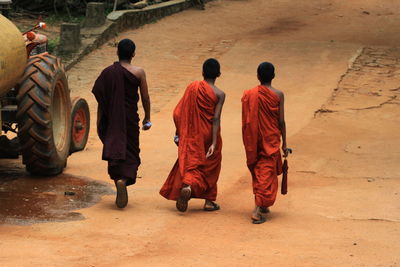 Rear view of monks walking on road