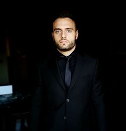 Portrait of handsome young man standing in darkroom