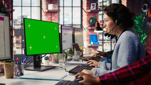 Side view of young woman using laptop at office