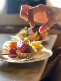 Close-up of hand holding ice cream in plate