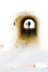 Full length of woman walking in tunnel