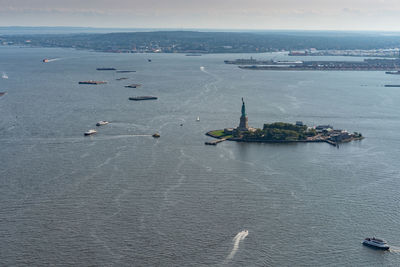 Aerial view of statue of liberty high angle view of ship sailing in sea against sky