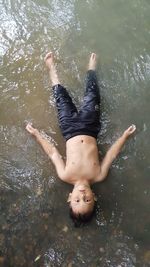 High angle view of shirtless boy in water