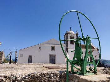 Low angle view of abandoned building against clear blue sky