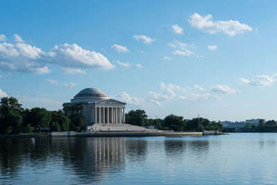 Reflection of historic building on lake against sky