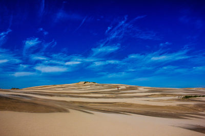 Scenic view of desert against blue sky